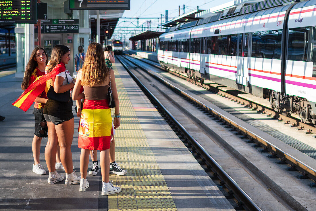 Spanische Fans warten auf den Zug, um an den Feierlichkeiten auf der Straße in Madrid teilzunehmen, nachdem der Europameister Spanien 2024 mit einem königlichen Empfang nach Hause zurückgekehrt ist, Madrid