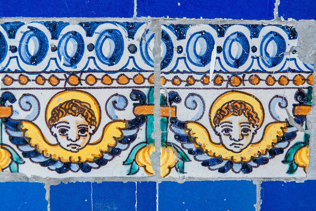 Cherubs depicted on ornate glazed ceramic tiles at the Fine Arts Museum in Seville, Spain, showcasing intricate artwork.