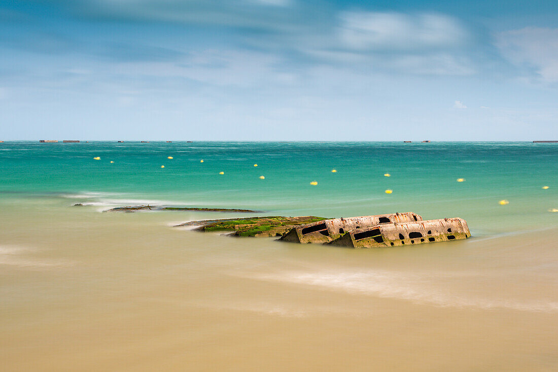 Langzeitaufnahme der Überreste von Mulberry B am Gold Beach in Arromanches, Normandie, Frankreich.