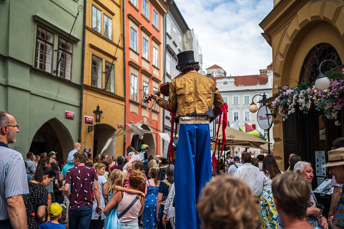 Artist plays violin while walking on stilts at the Parade of puppets from Marián Square to Old Town Square during the Prague Street Theatre Festival Behind the Door, Prague, Czech Republic