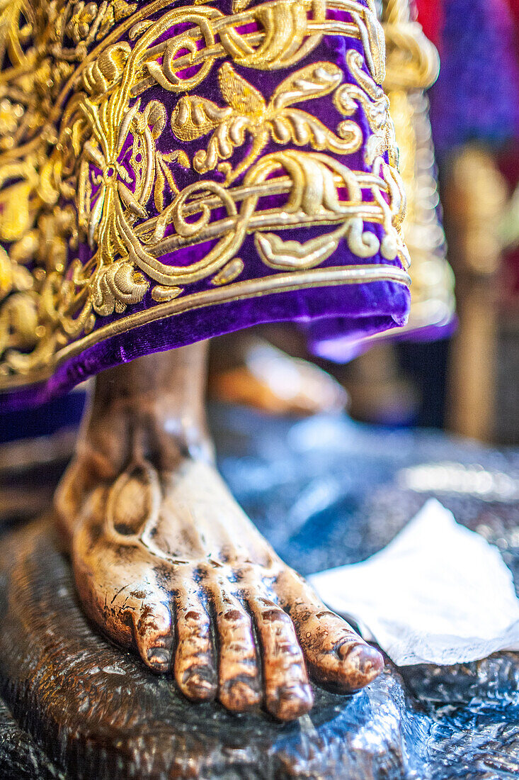 Komplizierte Nahaufnahme des Gewandes und des Fußes von Nuestro Padre Jesus Nazareno, einer Statue aus dem 17. Jahrhundert aus der Semana Santa de Sevilla, Spanien.