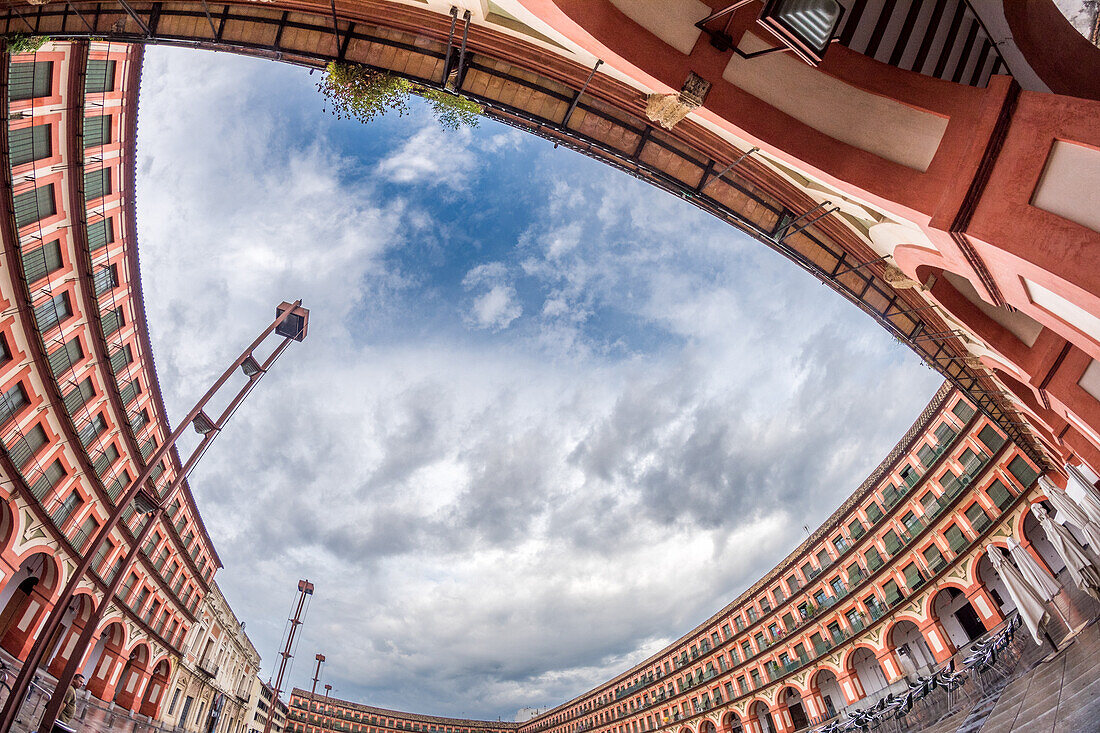 Fischaugenansicht der Plaza de la Corredera in Córdoba, Andalusien, die die architektonische Schönheit des Platzes unter einem bewölkten Himmel zeigt.