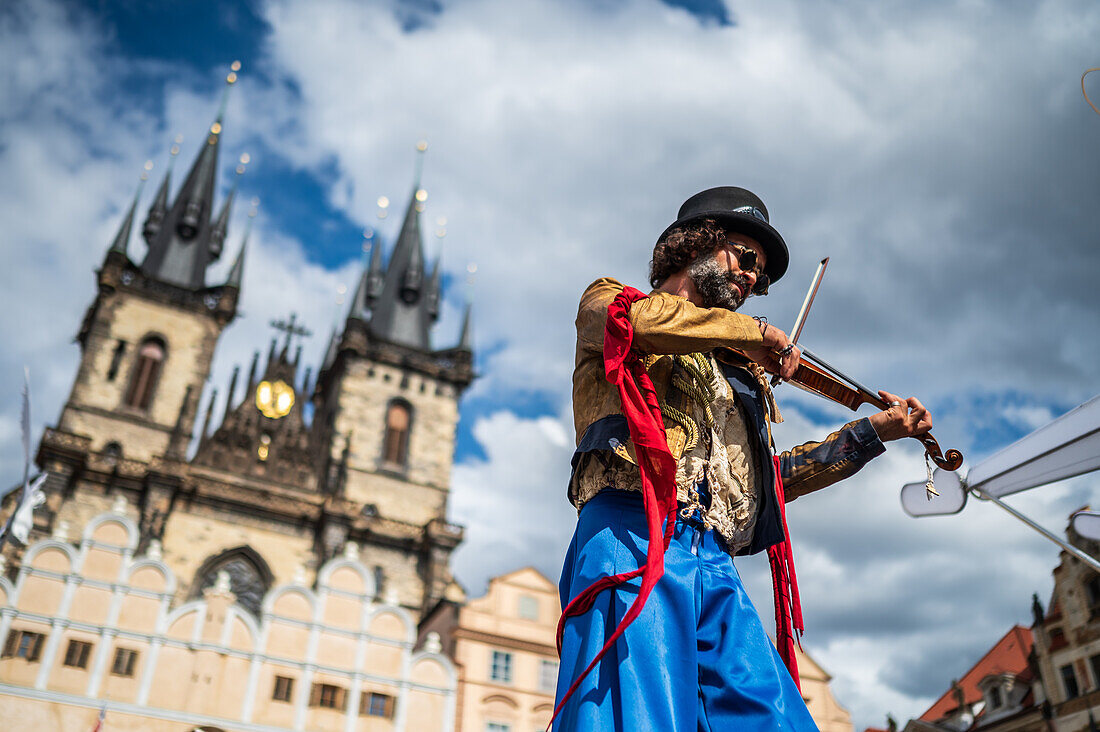 Artist plays violin while walking on stilts at the Parade of puppets from Marián Square to Old Town Square during the Prague Street Theatre Festival Behind the Door, Prague, Czech Republic