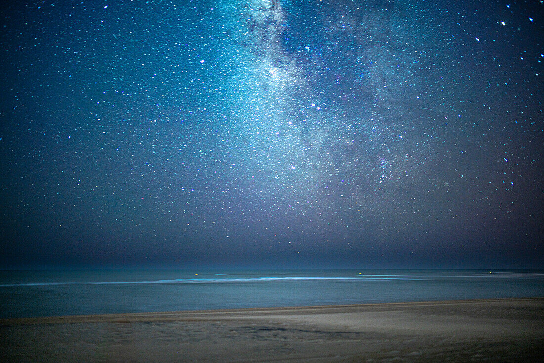 Sternenklarer Nachthimmel mit der Milchstraße über dem ruhigen Atlantik am Strand von Isla Canela, Ayamonte, Spanien.