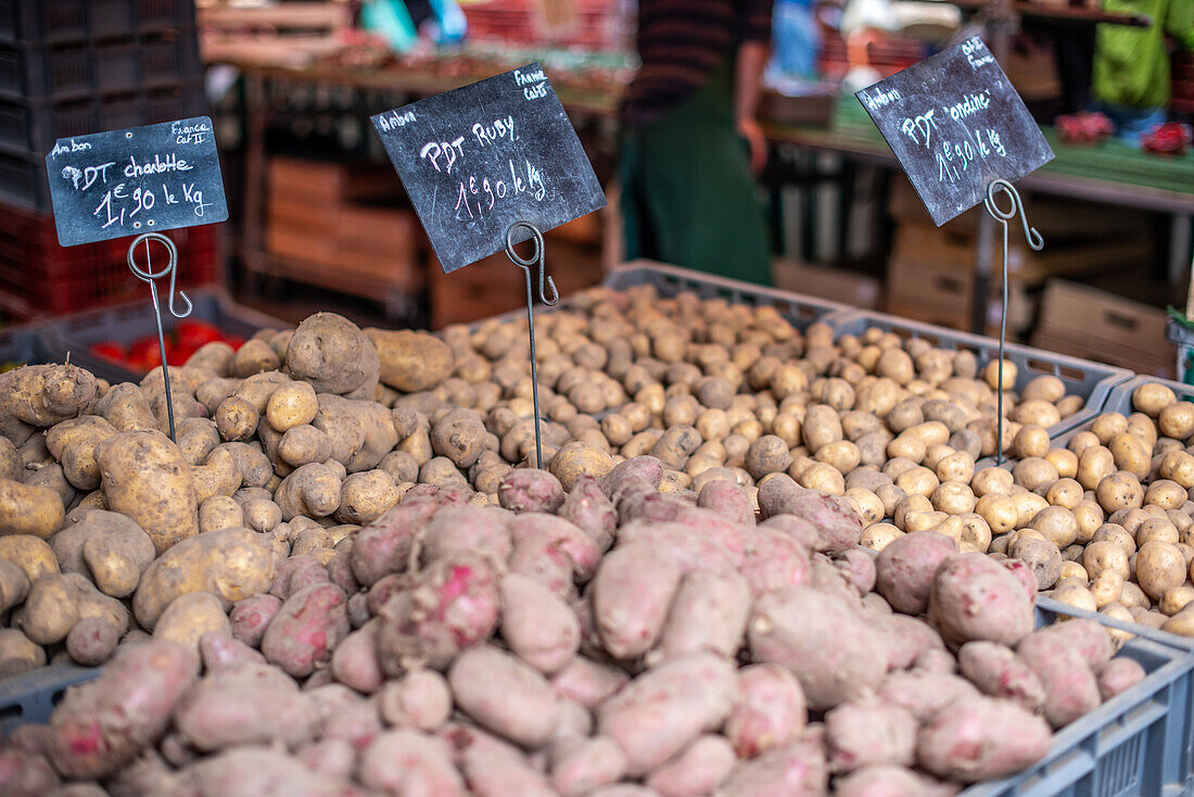 A wide selection of fresh potatoes at a local market in Vannes, Brittany, France. Showcasing local produce and the vibrant market atmosphere.