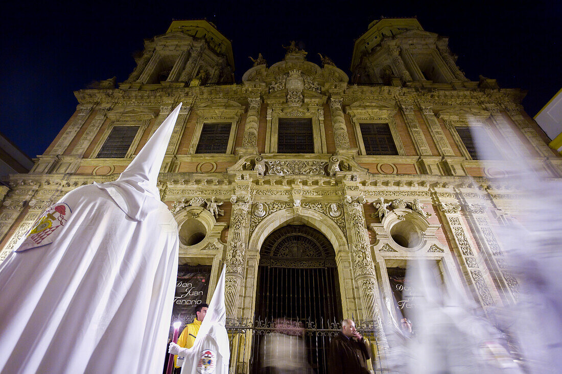 Nazarener der Cofradia del Resucitado bei der Prozession vor der Barockfassade von San Luis de los Franceses in Sevilla während der Semana Santa.