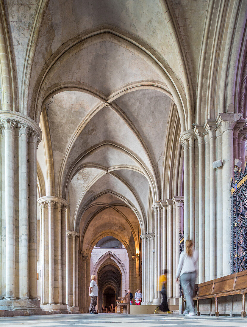 Historic interior of the Men's Abbey in the church of Saint Etienne, located in Caen, Normandy, France. People walking through the grand Gothic arches.