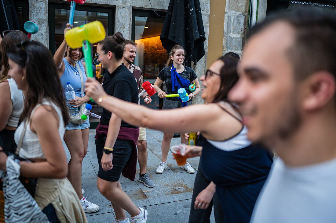 Begrüßung von Menschen mit welkem Lauch und Plastikhämmern während des Johannisfestes von Porto (Festa de Sao Joao do Porto ) in der Nacht zum 23. Juni (Johannisnacht) in der Stadt Porto, Portugal