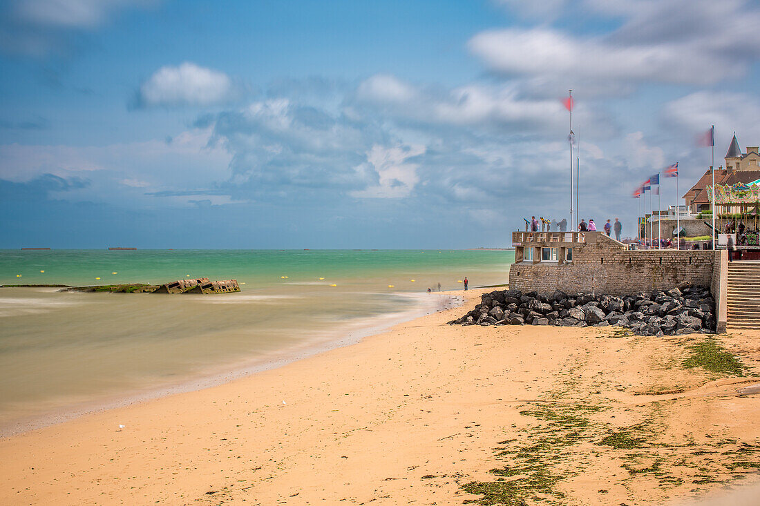 Lang belichtete Aufnahme der Überreste von Mulberry B am Gold Beach in Arromanches, Normandie, Frankreich. Ein landschaftlich reizvoller und historischer Ort am Meer.