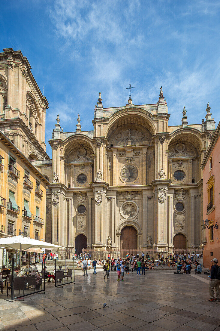 Ein schöner Blick auf die historische Catedral in Granada, Spanien, mit Touristen, die sich an einem sonnigen Tag versammelt haben. Die atemberaubende Architektur und die lebendige Atmosphäre sind gut zu erkennen.