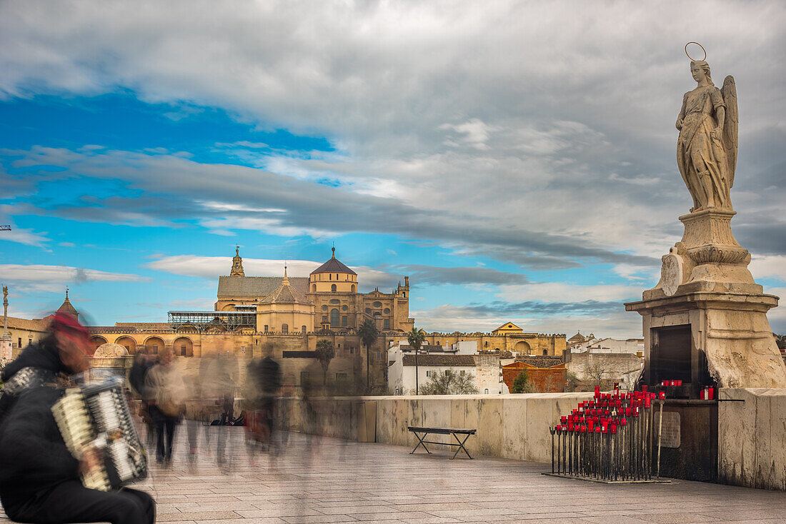 Statue von San Rafael auf der römischen Brücke in Cordoba, Andalusien, Spanien, mit der ikonischen Moschee-Kathedrale im Hintergrund.