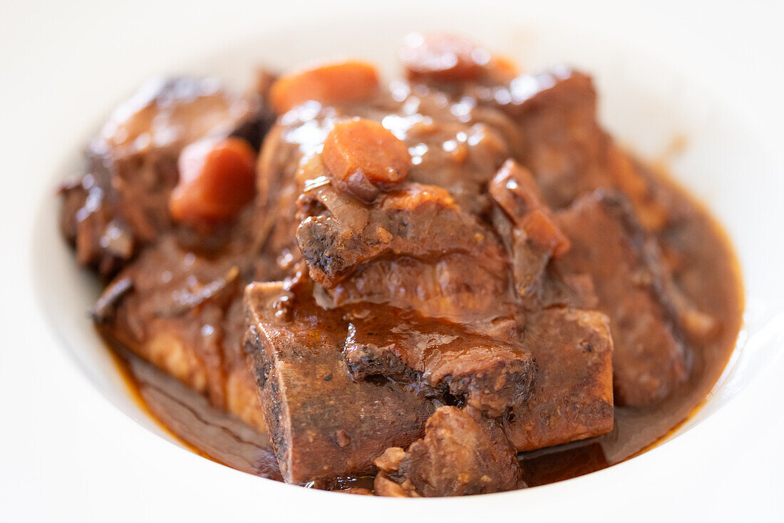 Close-up of traditional Andalusian rabo de toro stew served in a white bowl, showcasing its rich and hearty appearance.