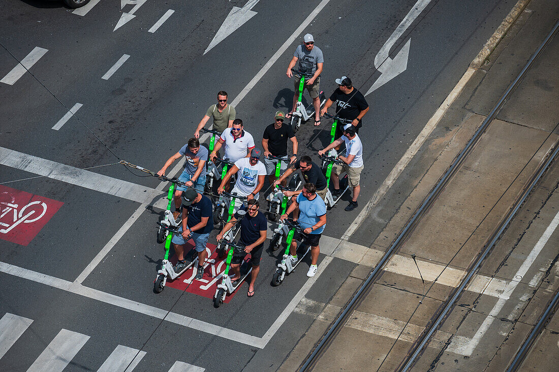 Gruppe von Touristen auf Motorrollern, Blick von oben, Prag