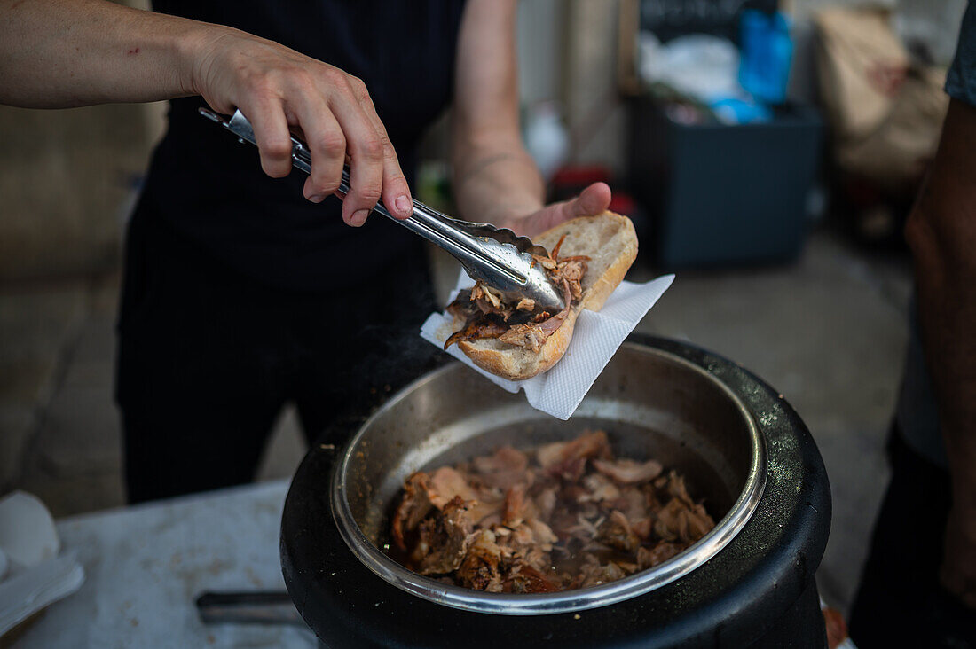 Traditionelles gebratenes Schweinefleischsandwich beim Johannisfest in Porto (Festa de Sao Joao do Porto ) während der Mittsommernacht am 23. Juni (Johannisnacht) in der Stadt Porto, Portugal