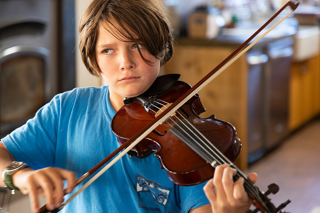 Boy playing violin at home