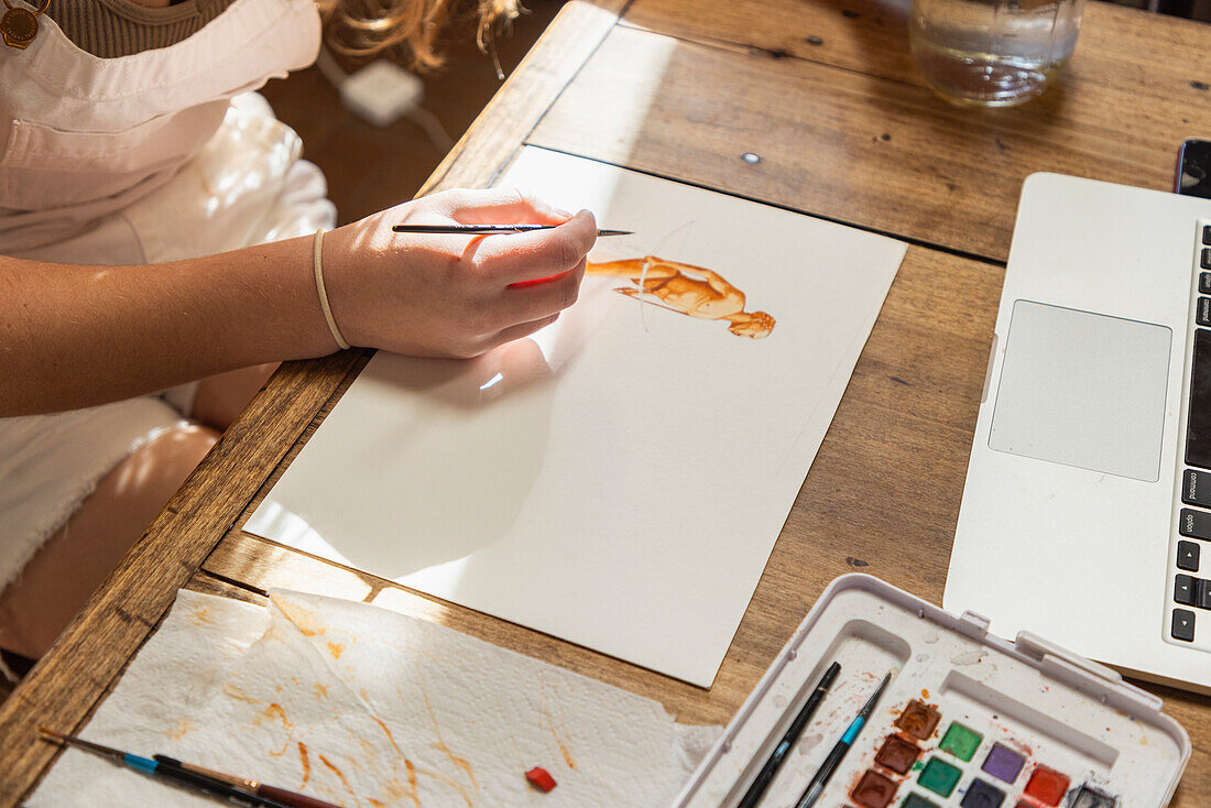 Nahaufnahme eines Mädchens, das mit Aquarellfarben am Tisch malt