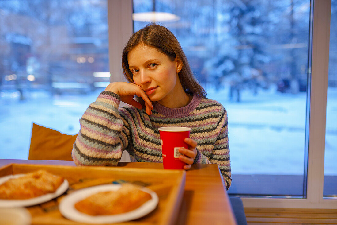 Porträt einer Frau beim Frühstück in einem Café