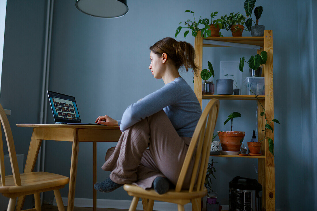 Frau benutzt Laptop zu Hause