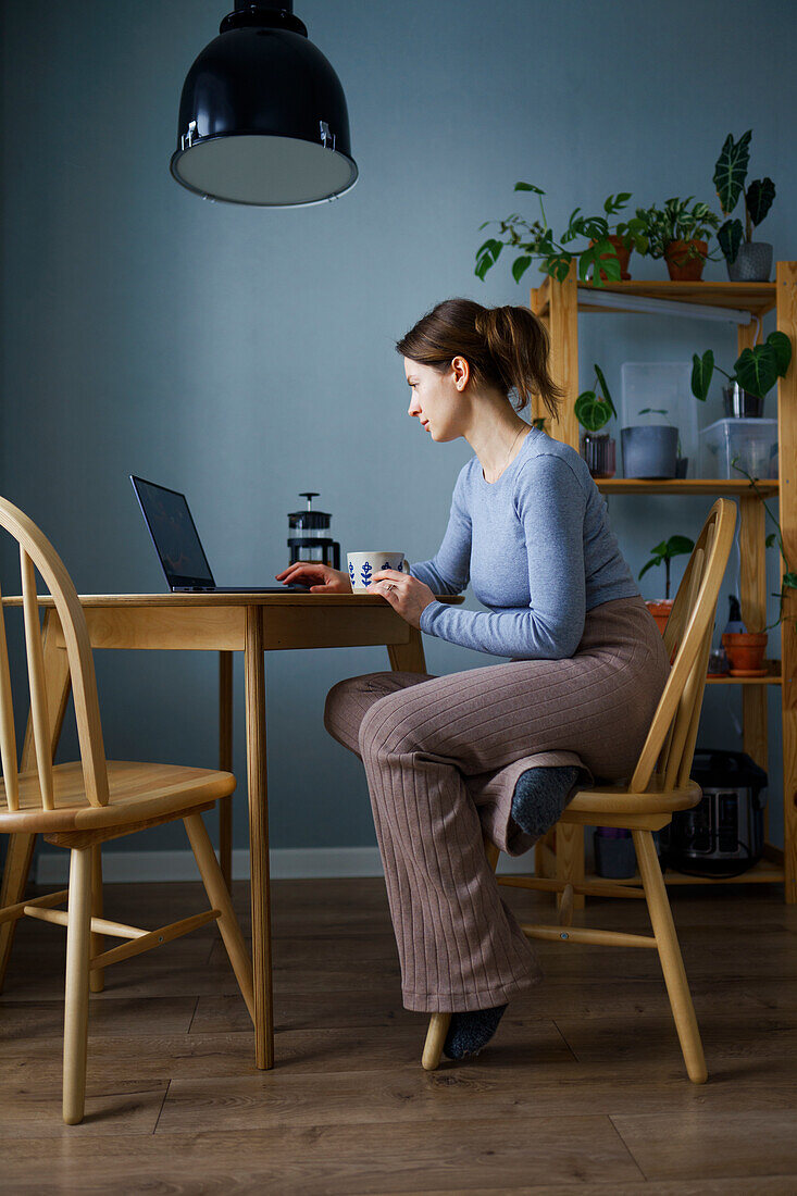 Frau benutzt Laptop zu Hause