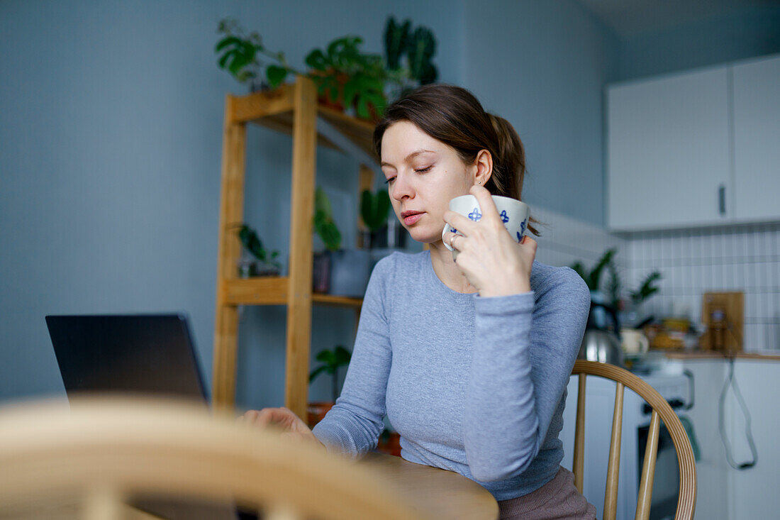 Frau benutzt Laptop zu Hause