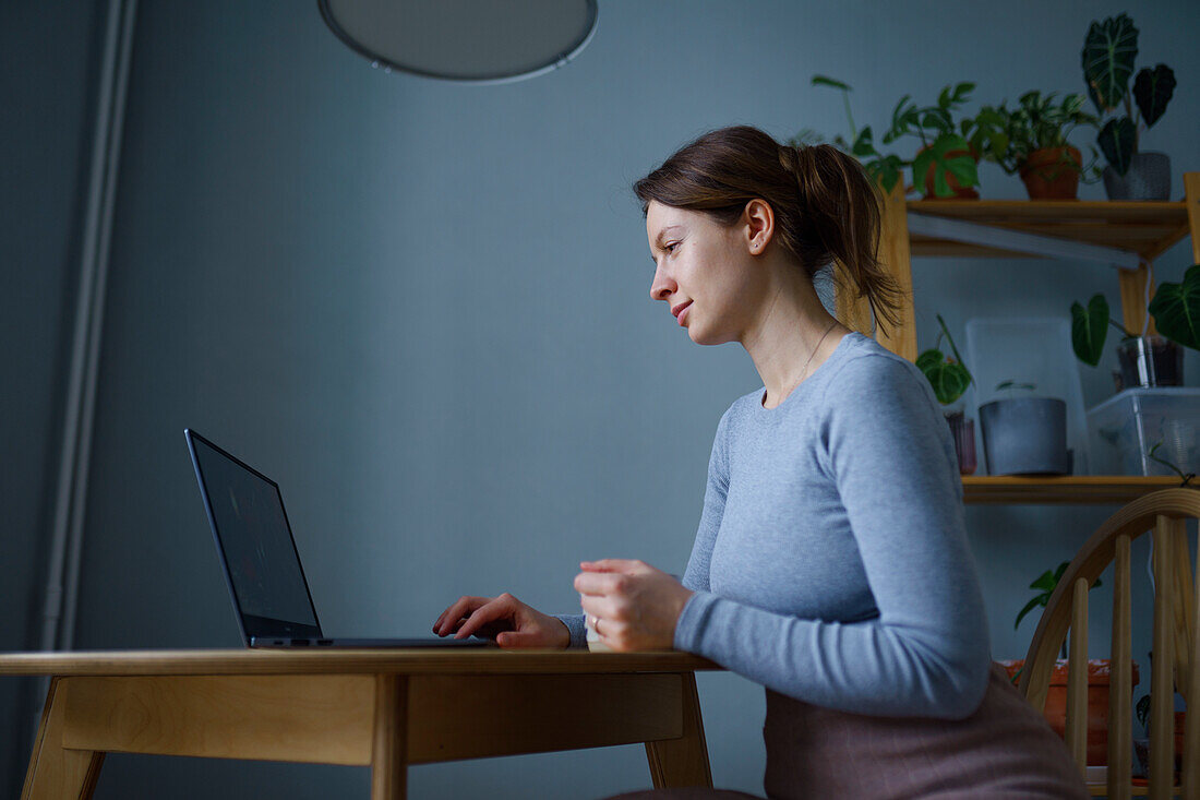 Frau benutzt Laptop zu Hause