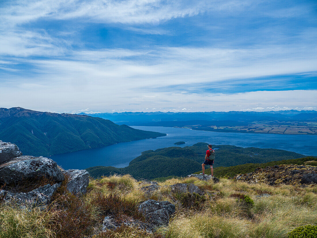 Hiker looking at fjord and mountains in Fiordland National Park