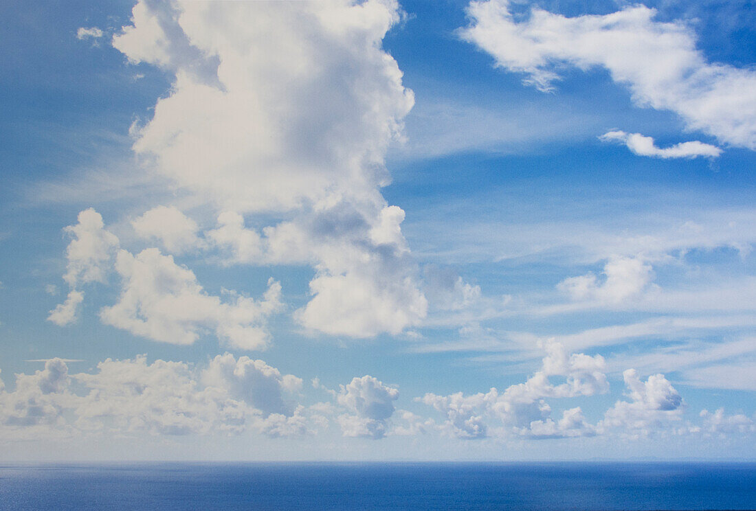 White puffy clouds above calm sea