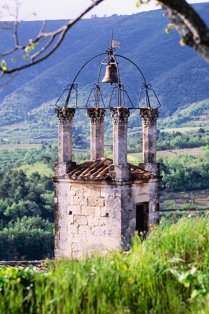 Alter Kirchenglockenturm in hügeliger Landschaft