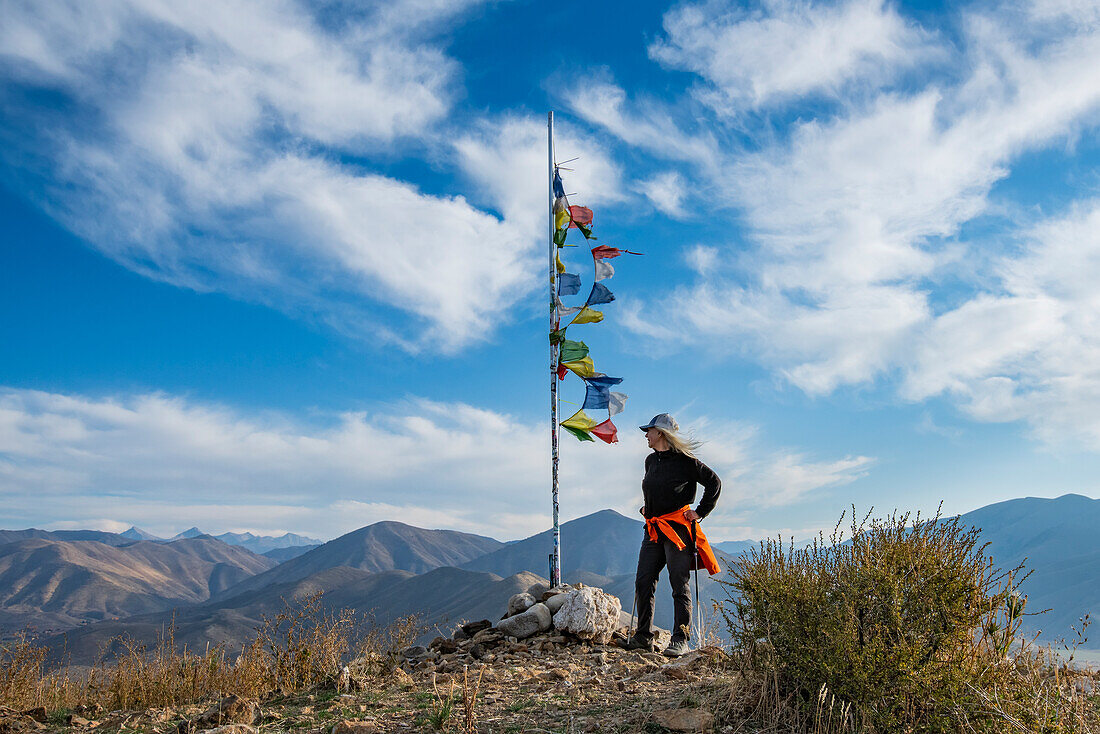 Female hiker atop Carbonate Mountain at prayer flags pole