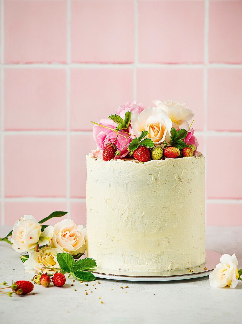 Festive buttercream sponge cake with strawberries and rose petals