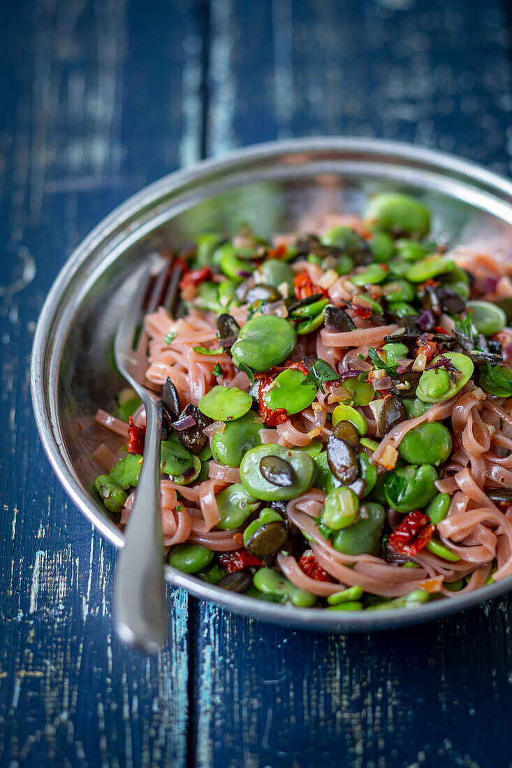 Red rice noodles with broad beans and sun-dried tomatoes