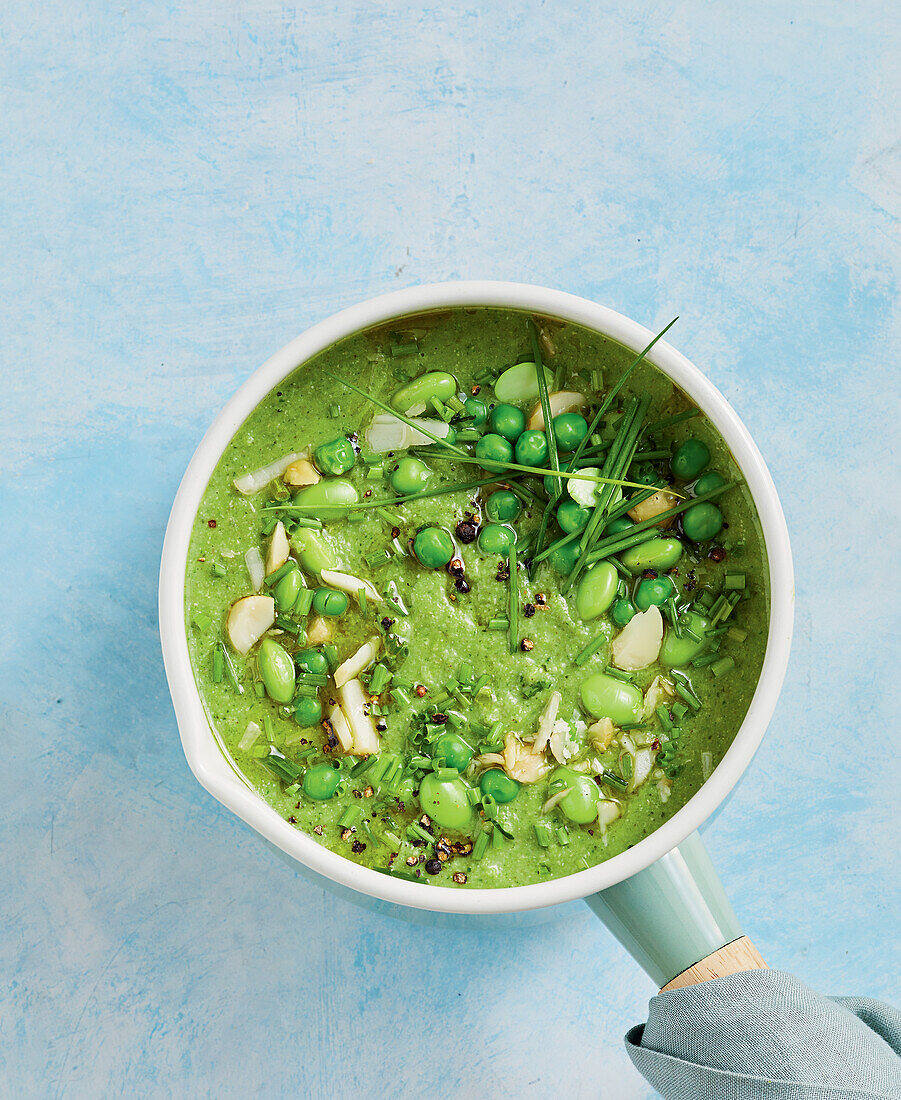 Erbsen-Edamame-Suppe garniert mit Mandeln und Schnittlauch