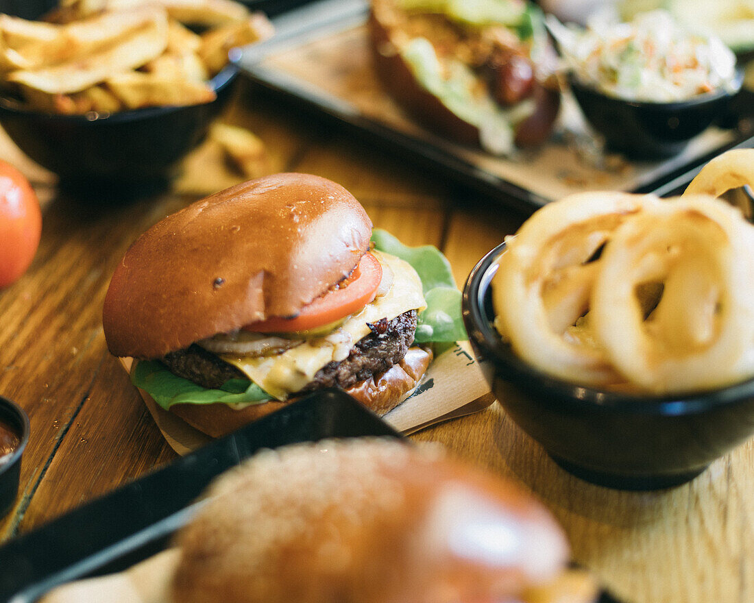 Cheeseburger mit Zwiebelringen und Pommes