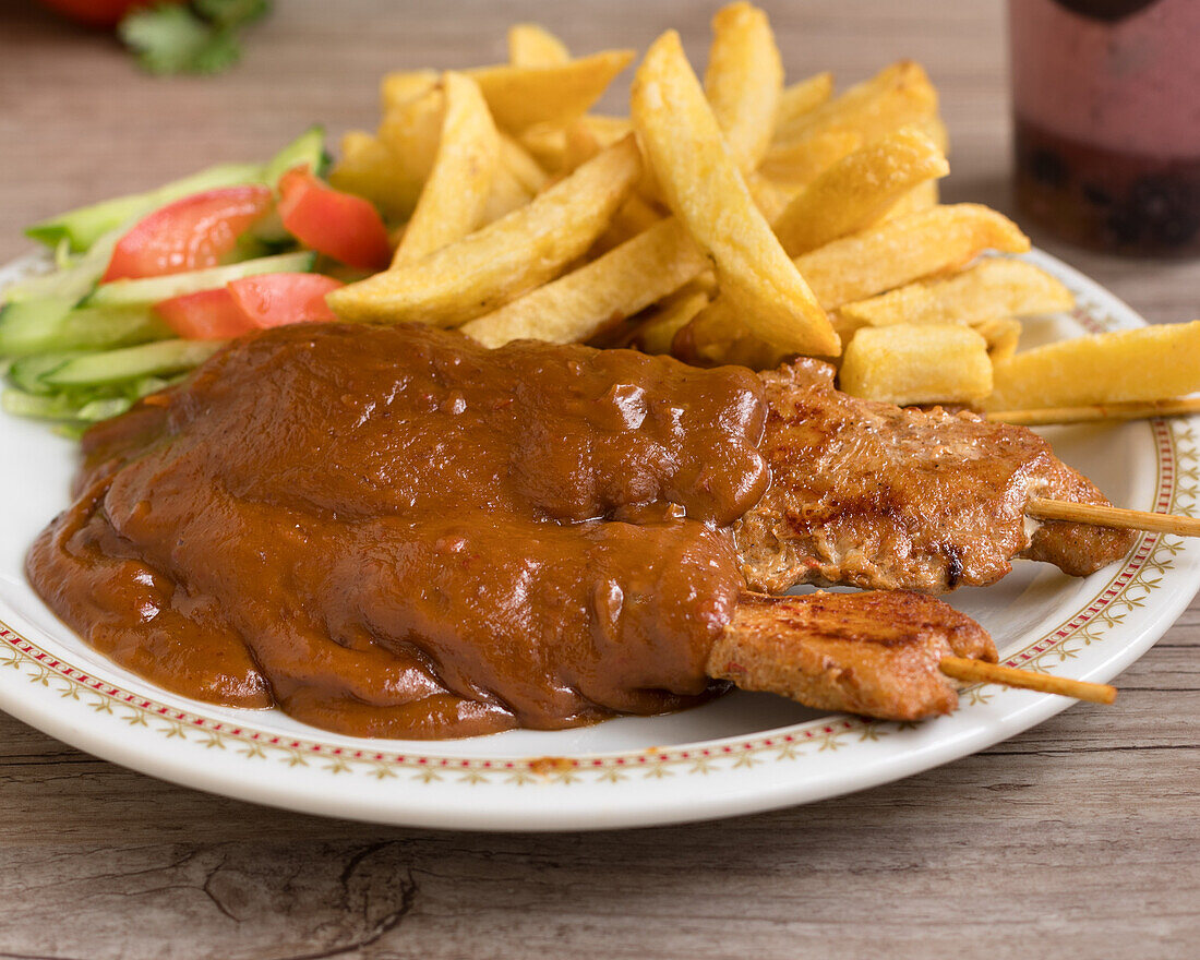 Sate-Spieße mit Erdnusssauce, Pommes und Salat