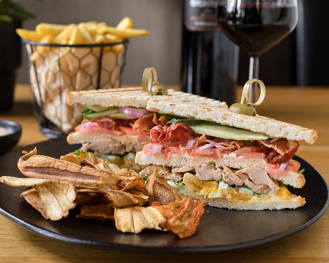 Club-Sandwich mit Hähnchen, Bacon und Pommes