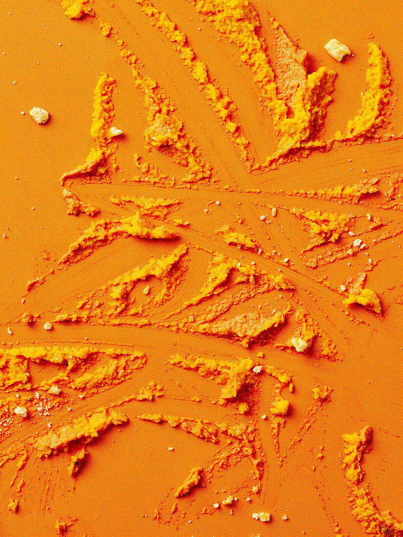 Turmeric powder on an orange-coloured background