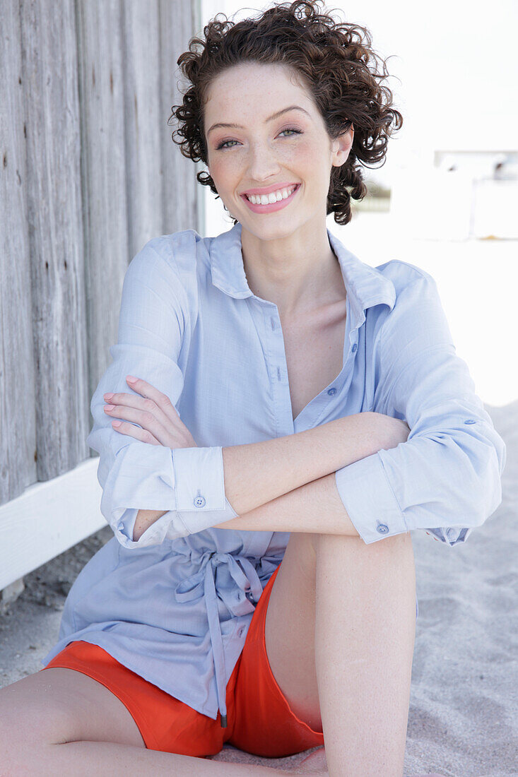 Young woman in light blue shirt dress and shorts