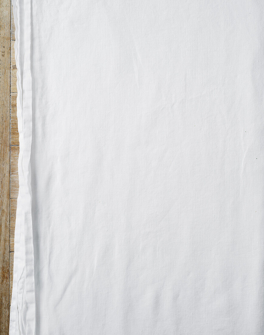 White tablecloth on wooden table - background