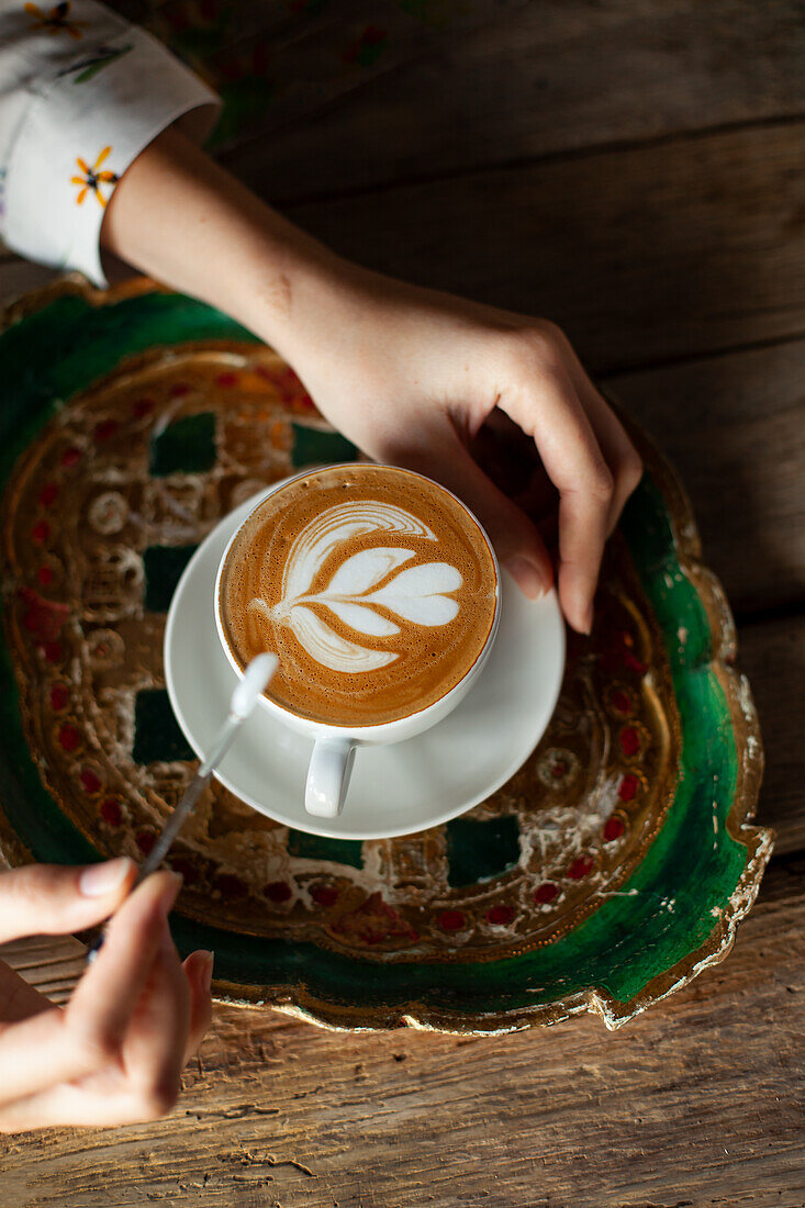 Cappuccino with latte art on traditional tray