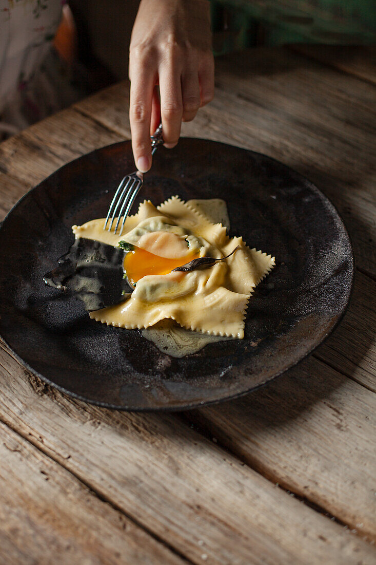 Raviolo filled with egg yolk and melted butter