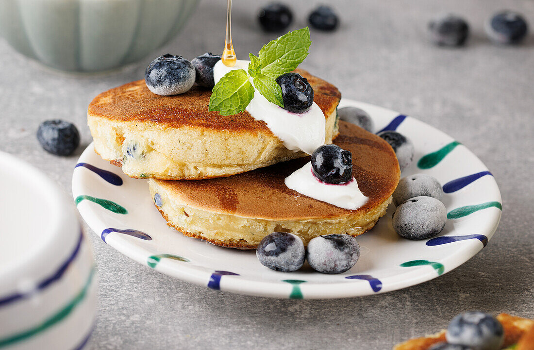 Blueberry pancakes with maple syrup and fresh blueberries