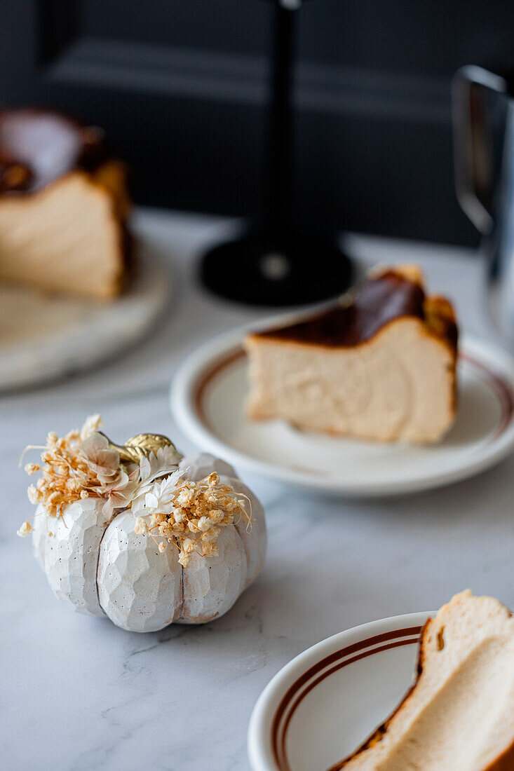 Decorative object in front of Basque cheesecake with caramelised crust