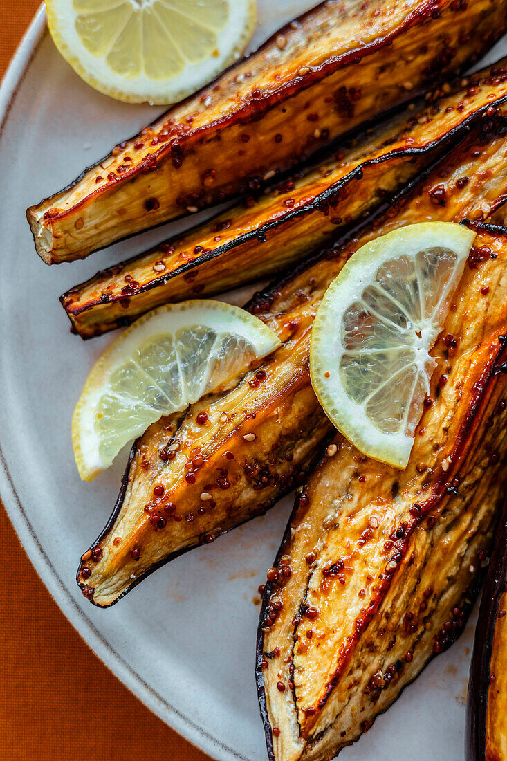 Oven-baked aubergines with honey and mustard glaze and lemon slices