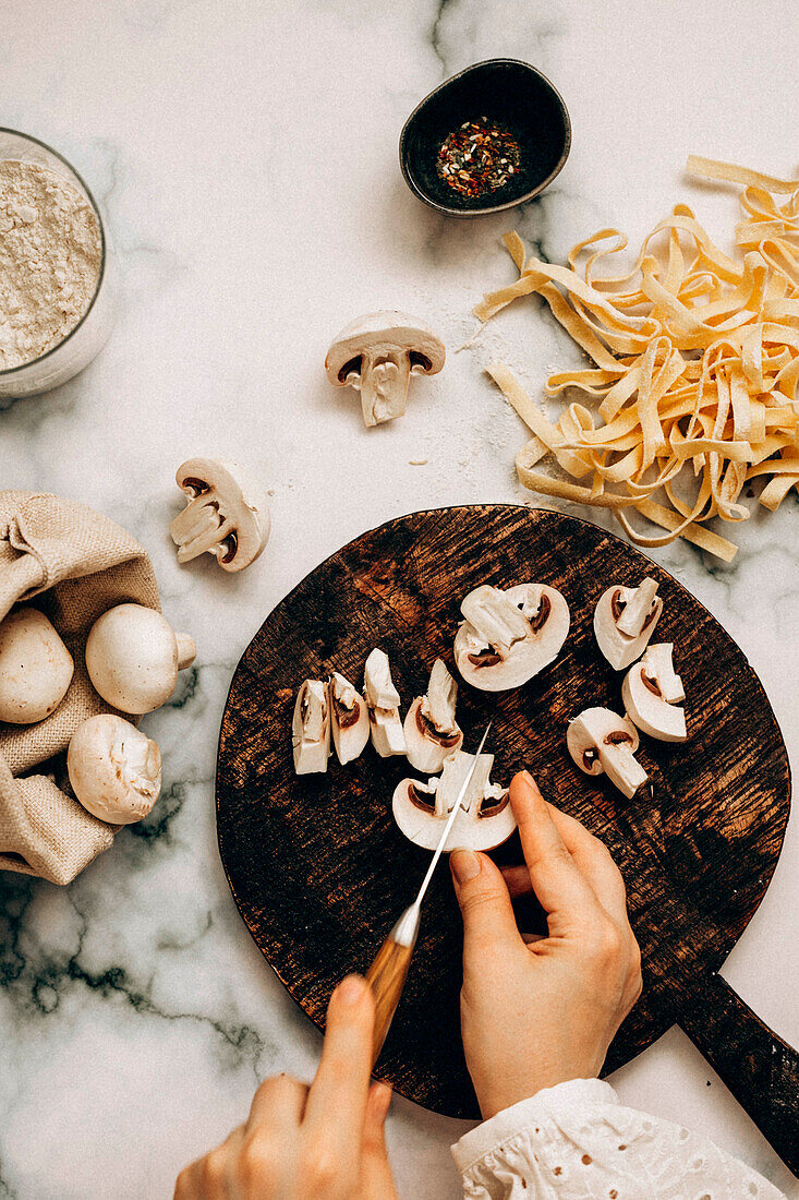 Homemade dried pasta and freshly sliced mushrooms