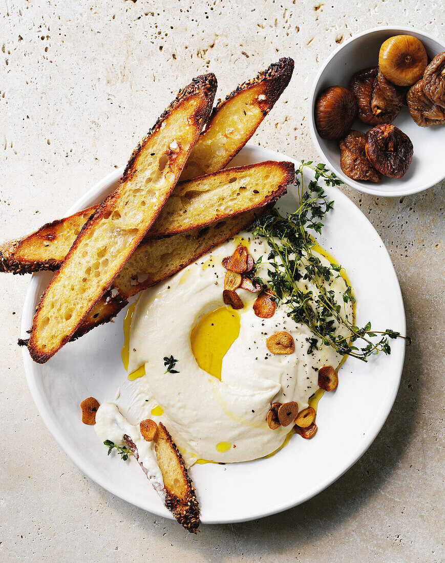 Käsedip mit Knoblauch, Olivenöl und geröstetem Brot