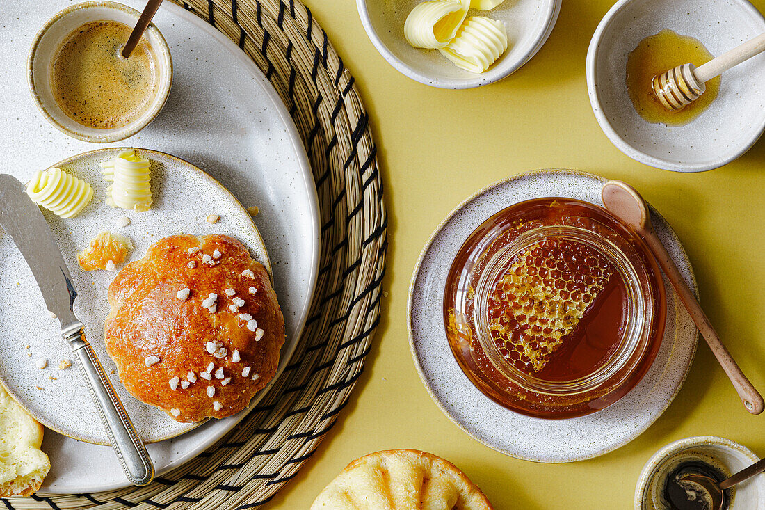 Breakfast with brioche and honey in a jar with honeycomb