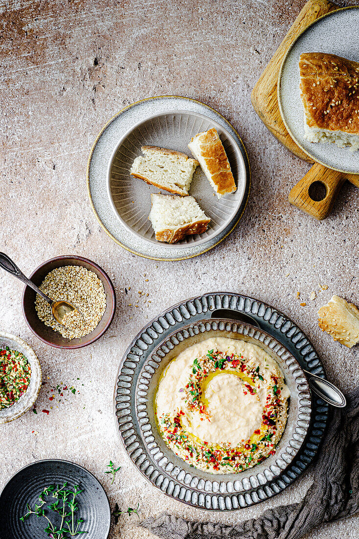 Hummus mit Öl, Sesam und Gewürzen, serviert mit Fladenbrot