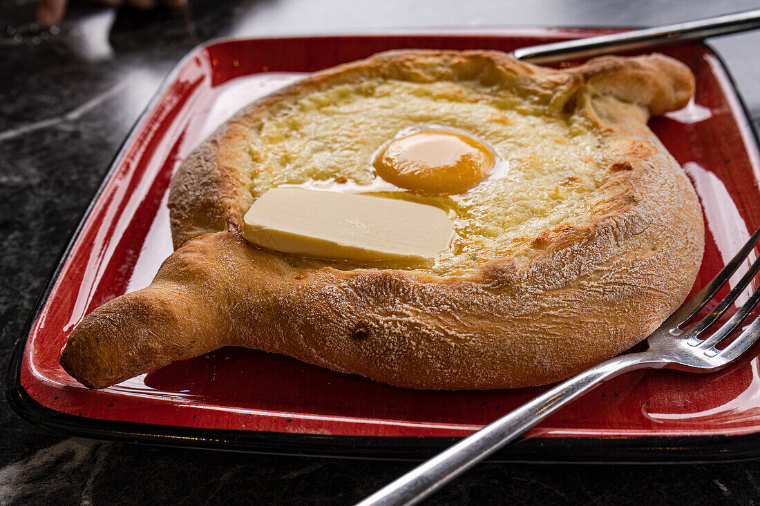 Khachapuri im adjarischen Stil mit Ei und Butter