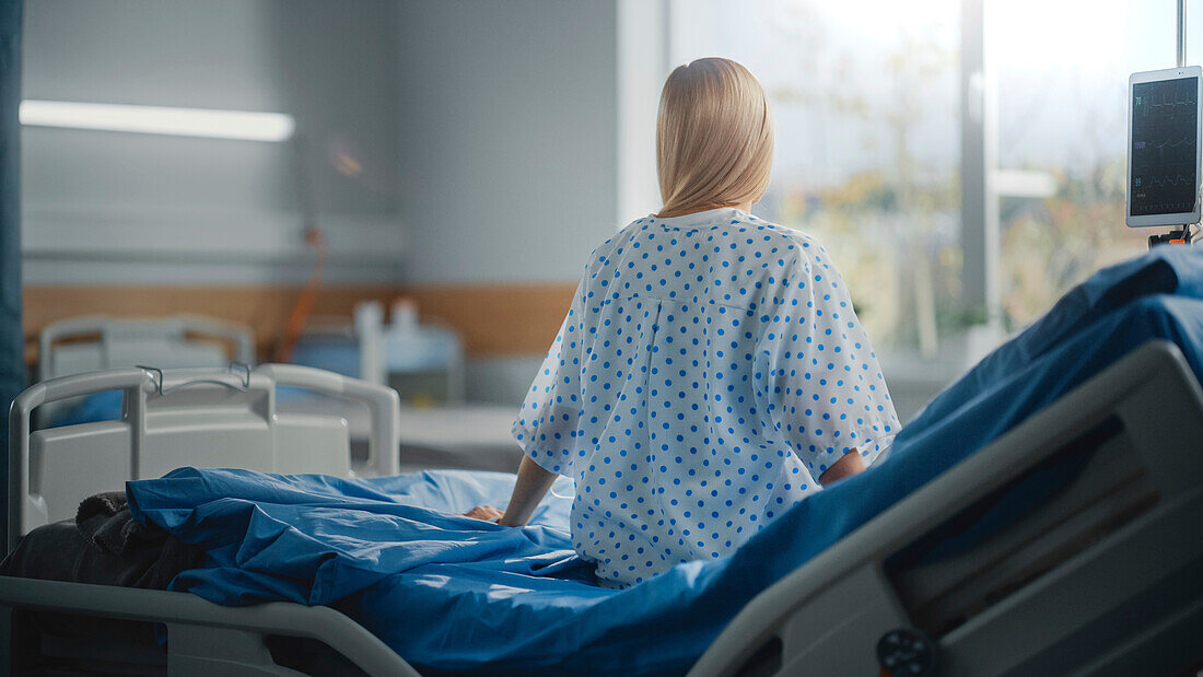 Female patient sitting on hospital bed