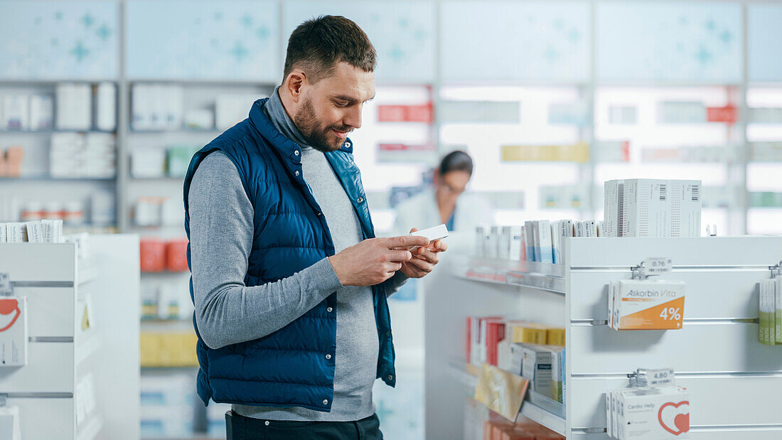 Male customer holding box of medicine